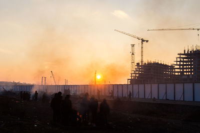 People on street against sky during sunset