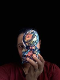 Portrait of boy wearing mask against black background