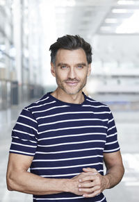 Portrait of smiling mature man with stubble wearing stripes t-shirt