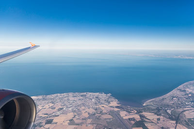 Airplane flying over manston international airport with sea and french coastline in background 