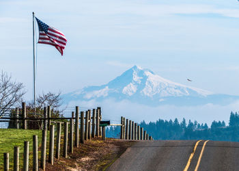 Flag by mountains against sky