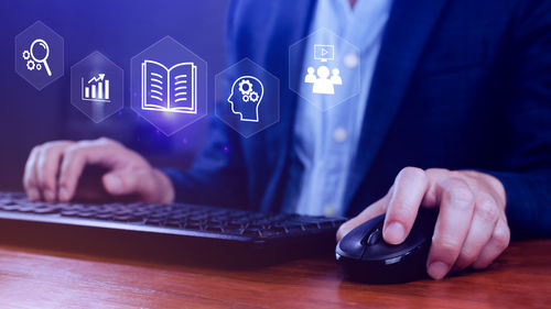 Midsection of businessman using laptop on table