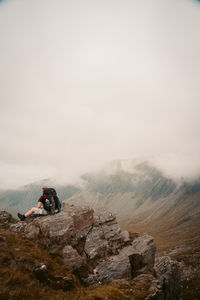 Man on rock against sky