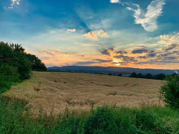 Scenic view of field against sky during sunset