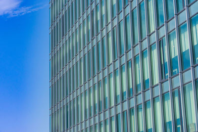 Low angle view of modern building against blue sky