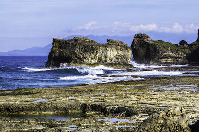 Scenic view of sea and cliff against sky