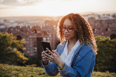 Young woman using mobile phone outdoors