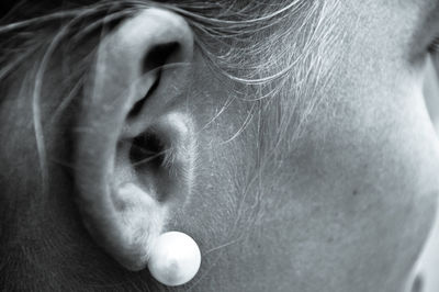 Cropped image of young woman wearing pearl earring