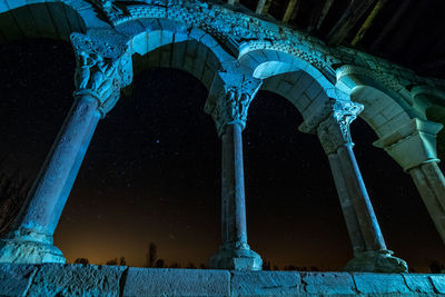Low angle view of illuminated lighting equipment at night