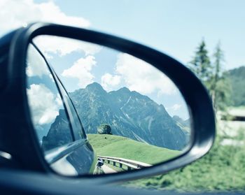 Reflection of sky on side-view mirror of car