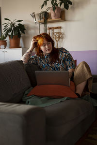 Woman on sofa using laptop