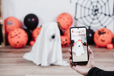 Cropped hand of woman photographing ghost puppy