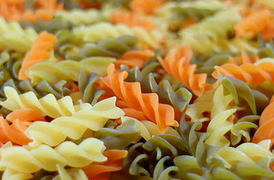 Closeup a pile of three-color spiral shaped fusilli pasta for background or wallpaper