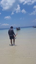 Scenic view of beach against cloudy sky