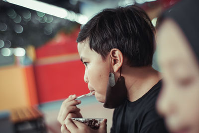 Side view of young boy drinking glass