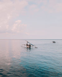 Fishing boat in sea against sky