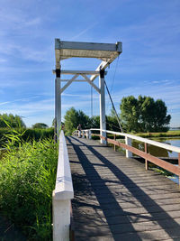 Railing by footpath against sky