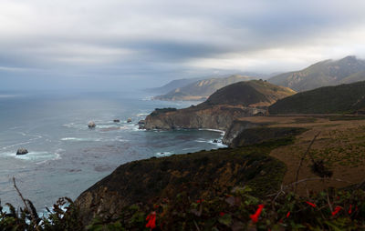 Scenic view of sea and mountains against sky