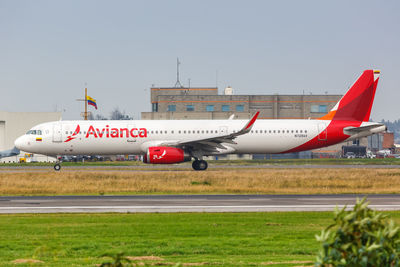 Airplane on airport runway against sky