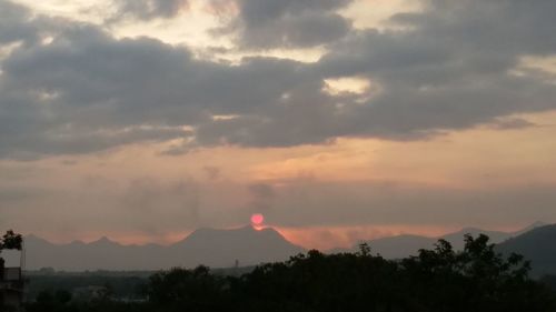 Scenic view of silhouette mountains against sky at sunset