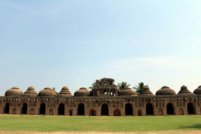 Historic building on field against clear sky