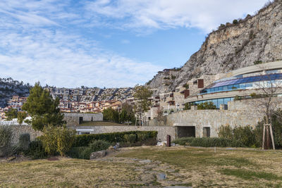 Houses by buildings against sky