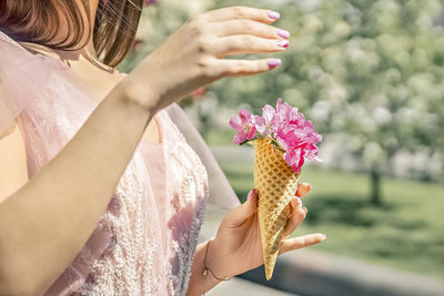 Flowers in a waffle cone in a woman's hand. the flowering of fruit trees in the garden