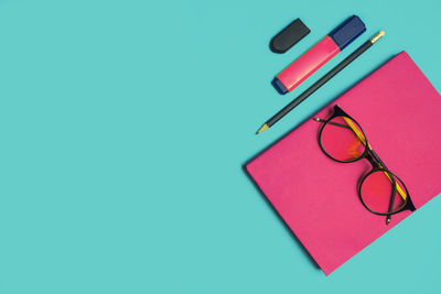 High angle view of multi colored pencils on table against blue background