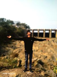 Full length of young man standing against sky