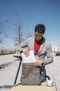 Man holding umbrella against sky