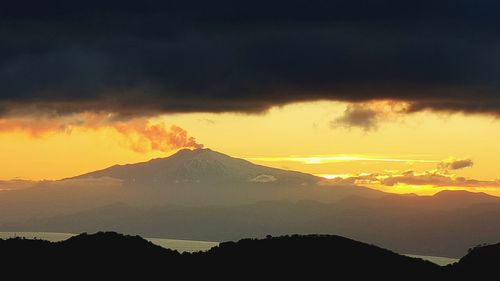 Scenic view of silhouette mountains against sky during sunset