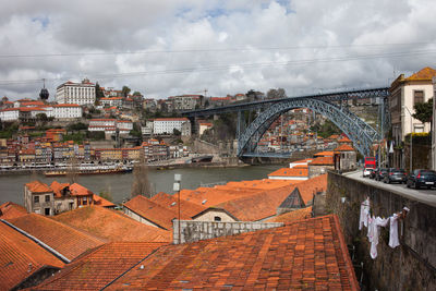 Bridge over river in city against sky