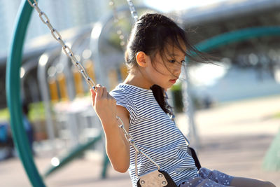 Cute girl swinging in playground