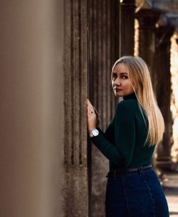 Portrait of woman standing against wall