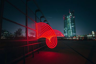 Light painting against modern buildings in city at night