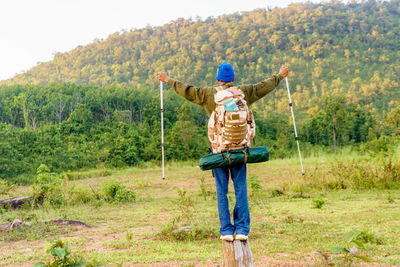 Full body man standing on field with forest and mountains traveling isolated