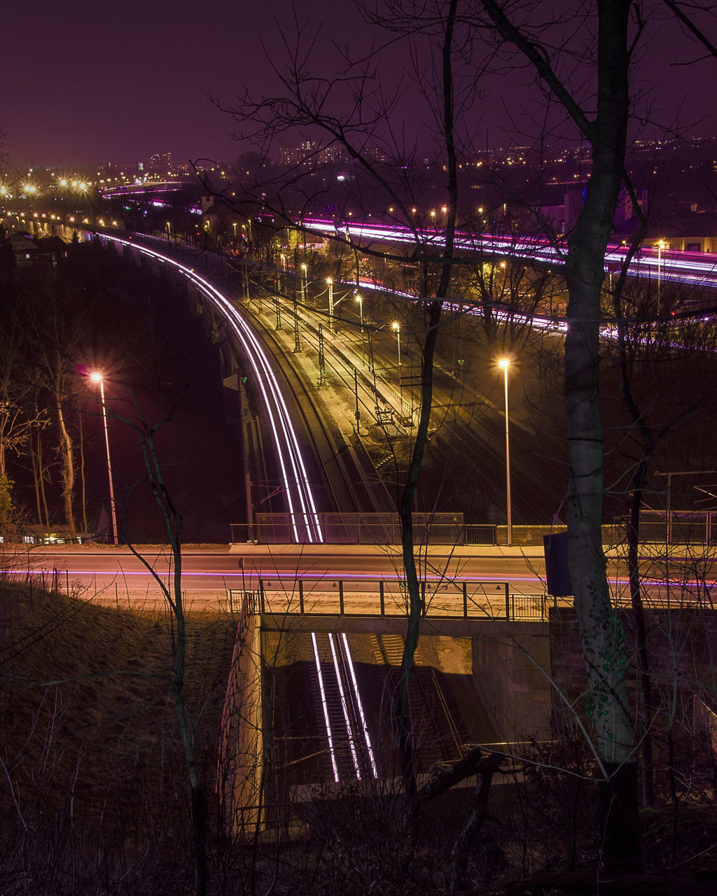 ILLUMINATED LIGHT TRAILS ON ROAD AT NIGHT