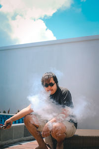 Full length of young woman smoking outdoors