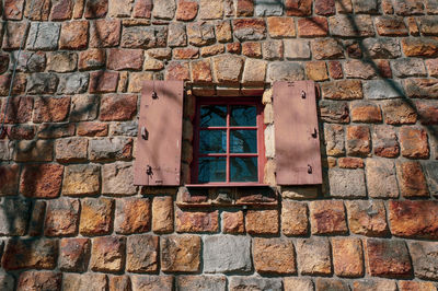 Low angle view of window on brick wall of building