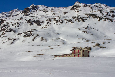 House on snowy hill during sunny day