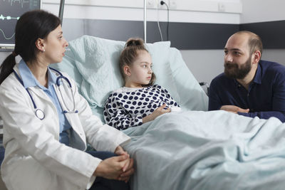 Doctor talking with patients father at hospital