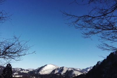 Scenic view of mountains against clear blue sky