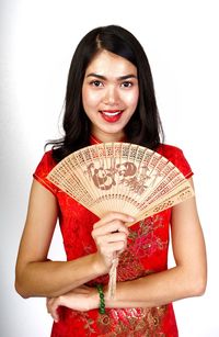 Portrait of a smiling young woman against white background