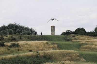 Windmill on field against sky