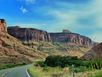 Road leading towards mountains against sky