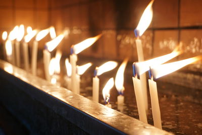 Close-up of candles burning in temple