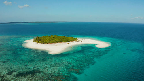 Sandy beach and tropical island by atoll with coral reef and axure water, top view. patawan island 