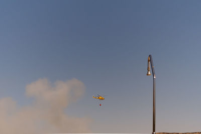 Low angle view of helicopter flying in sky