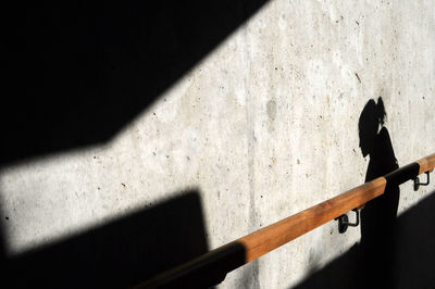 Shadow of person falling on concrete wall