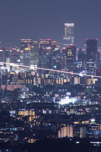 Illuminated cityscape against sky at night